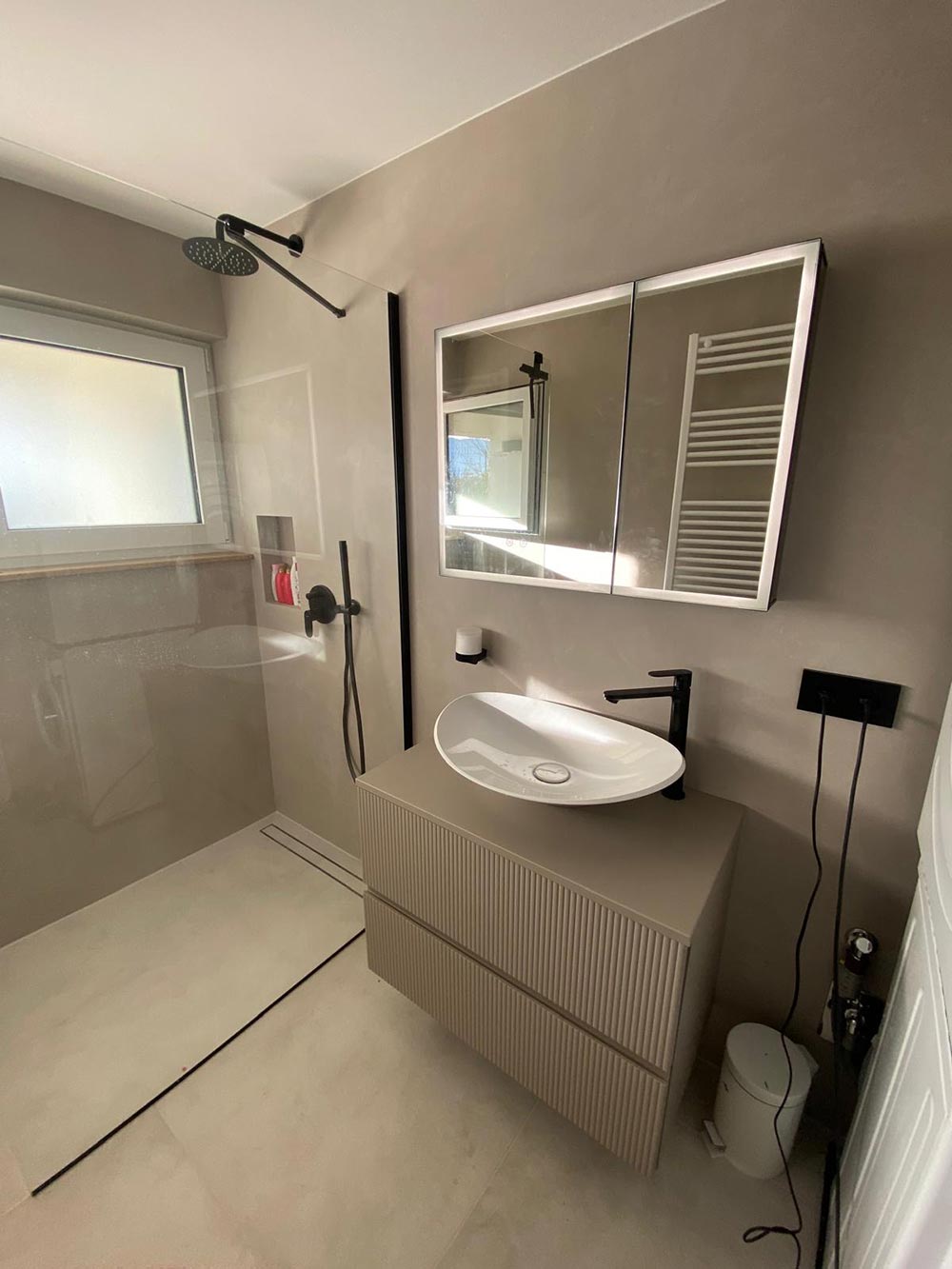 Modernes Bad ohne Personen, ruhig, beige grau, Glasdusche, Spiegel, schwarzer Armatur